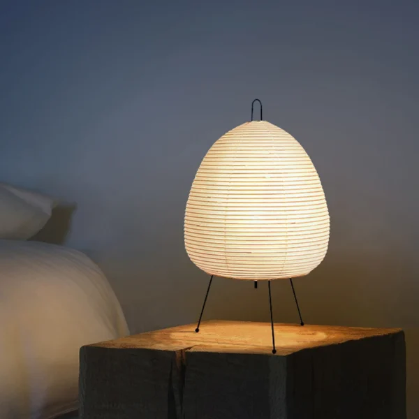 Rijstpapierlamp met drie slanke zwarte metalen pootjes, 47 cm hoog en 28 cm breed, die warm licht verspreidt en past bij Japandi en Wabi Sabi interieurstijl.