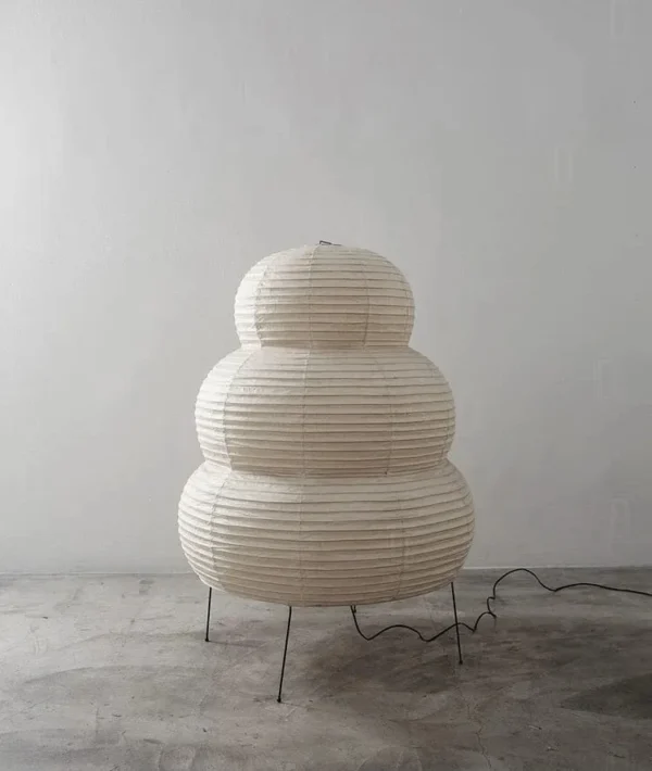 Rijstpapierlamp met vier slanke zwarte metalen pootjes, 60 cm hoog en 40 cm breed, die warm licht verspreidt en past bij Japandi en Wabi Sabi interieurstijl.