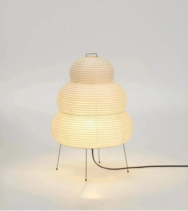 Rijstpapierlamp met vier slanke zwarte metalen pootjes, 60 cm hoog en 40 cm breed, die warm licht verspreidt en past bij Japandi en Wabi Sabi interieurstijl.